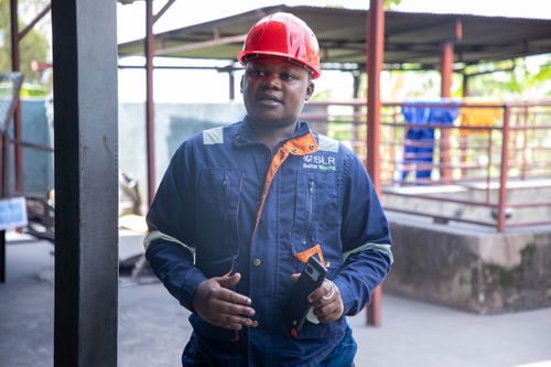 Free A mining engineer in safety gear stands confidently at an industrial site, showcasing modern safety standards. Stock Photo