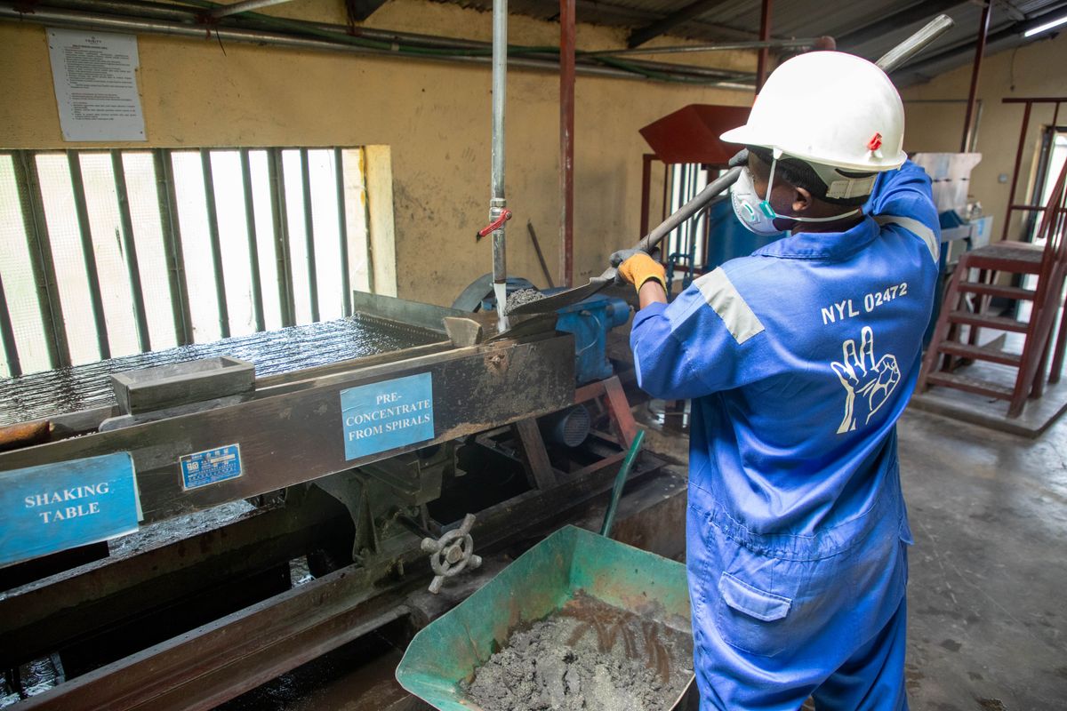 A worker operating ore-processing equipment, representing local beneficiation and value addition
