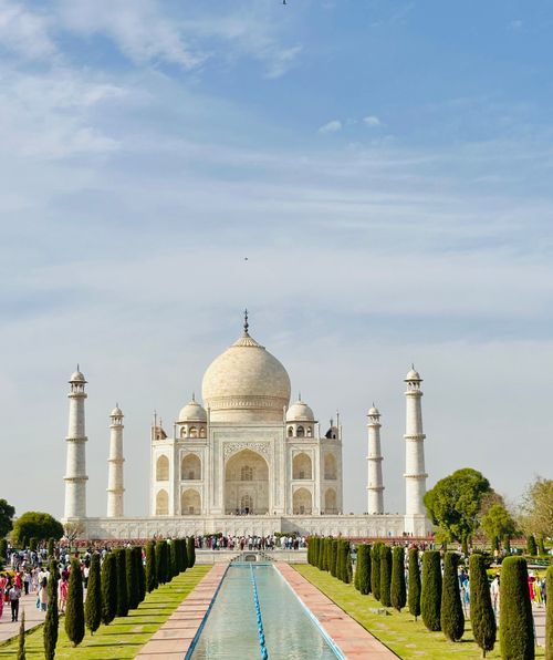 Free Stunning daytime view of the iconic Taj Mahal surrounded by gardens. Stock Photo