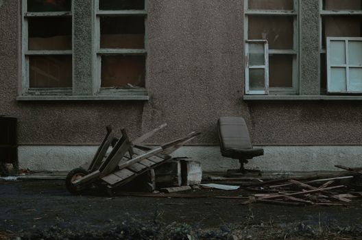 An old, derelict building exterior with scattered debris, showing urban decay.