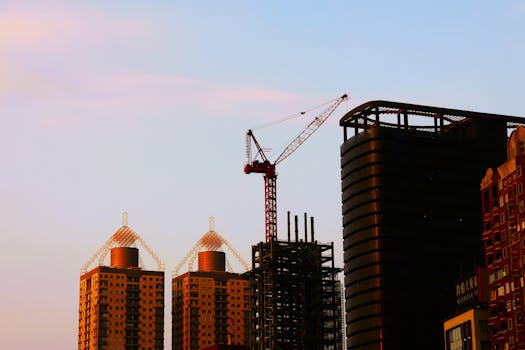 Silhouette di edifici e gru contro il cielo crepuscolare nel vivace paesaggio urbano di Taipei.
