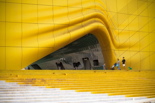 Vibrant yellow architectural facade with people walking, showcasing modern design in South Korea.