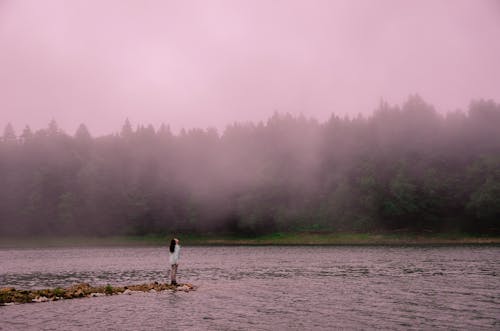 湖の近くに立っている間見上げる女性