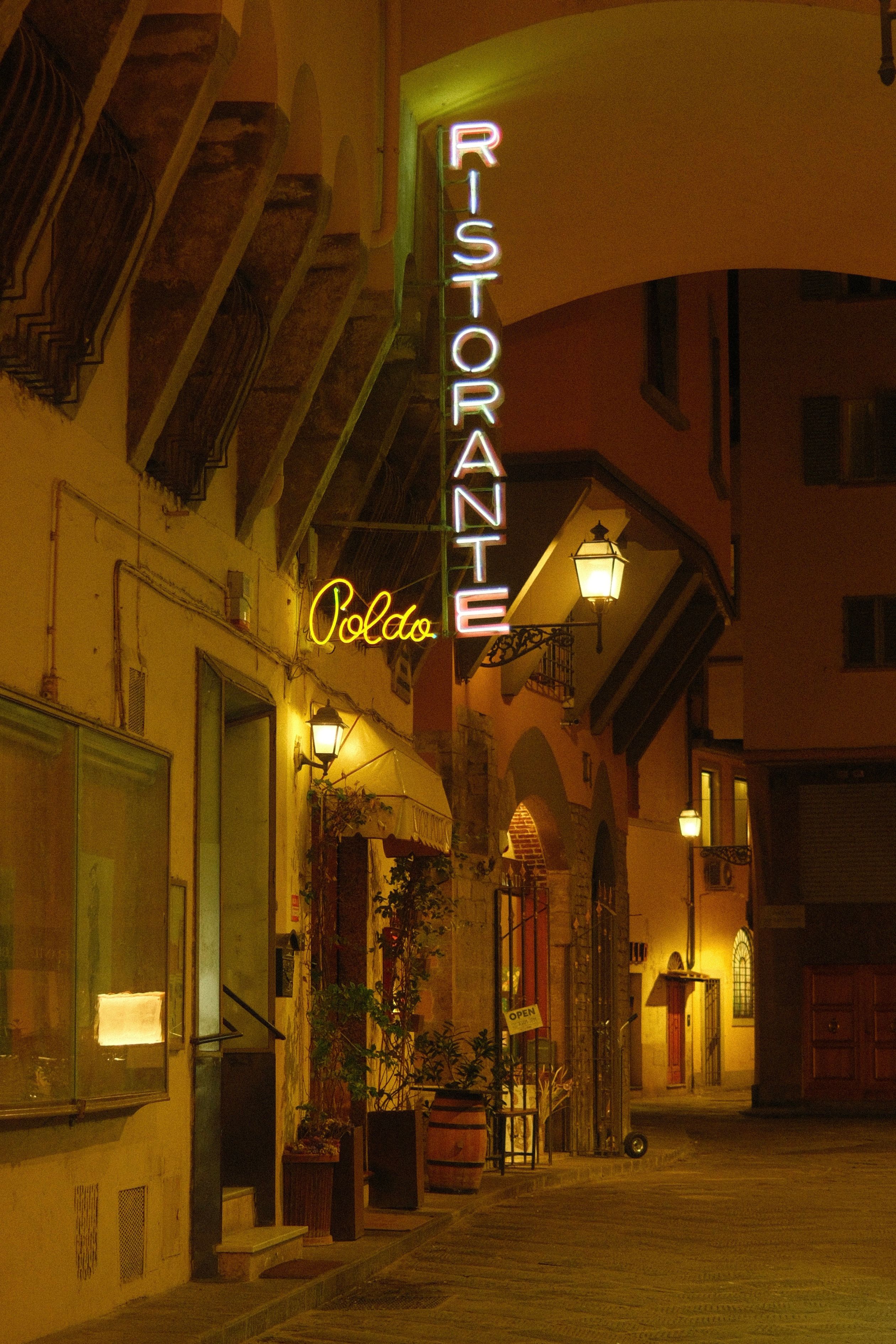 Romantic night view of restaurant in Florence, Italy, featuring warm lights and architecture.
