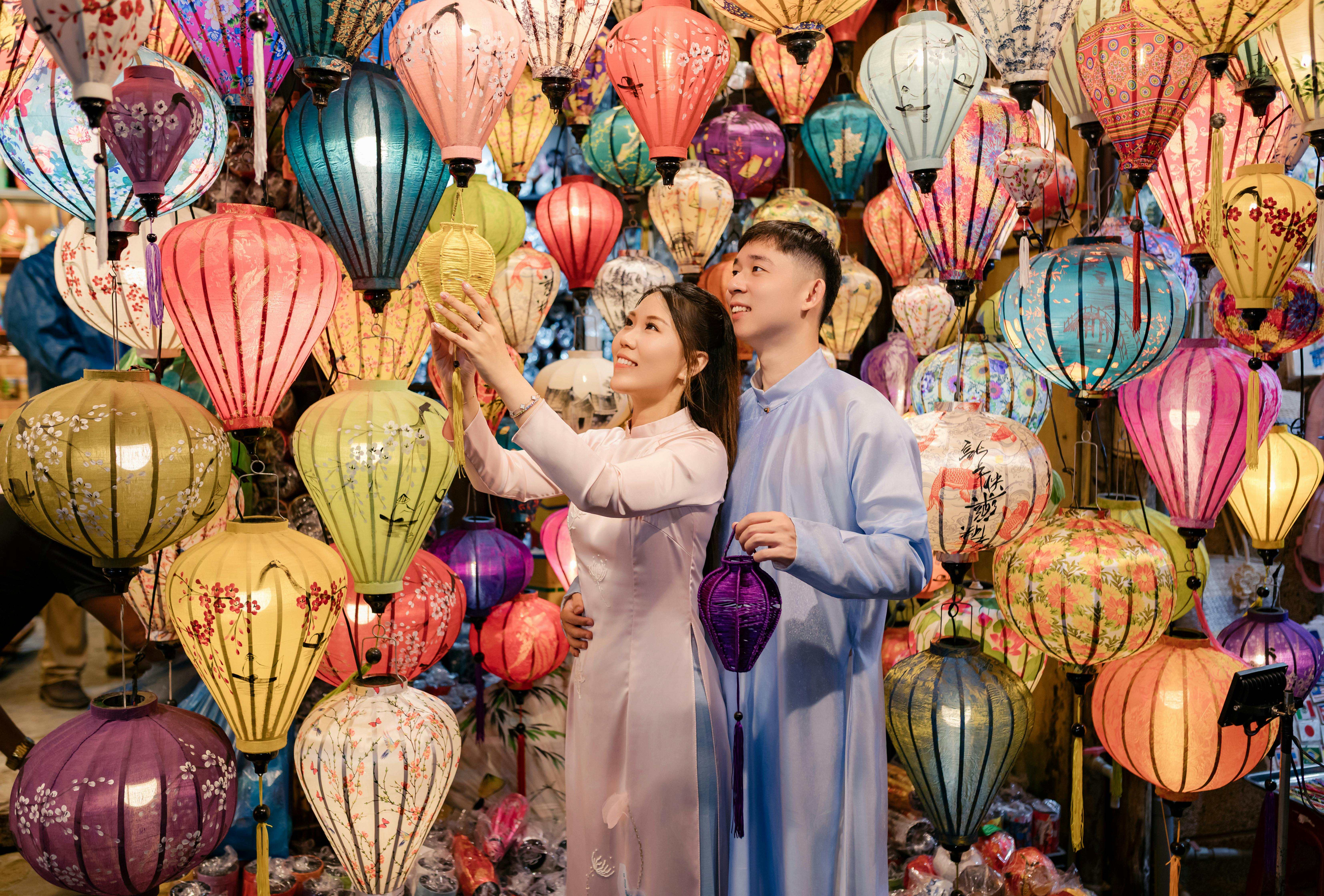 Couple enjoying vibrant lanterns at Hội An night market, Vietnam.