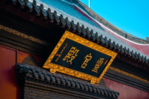 Free Close-up of an ornate Chinese signboard on a temple under a clear blue sky. Stock Photo
