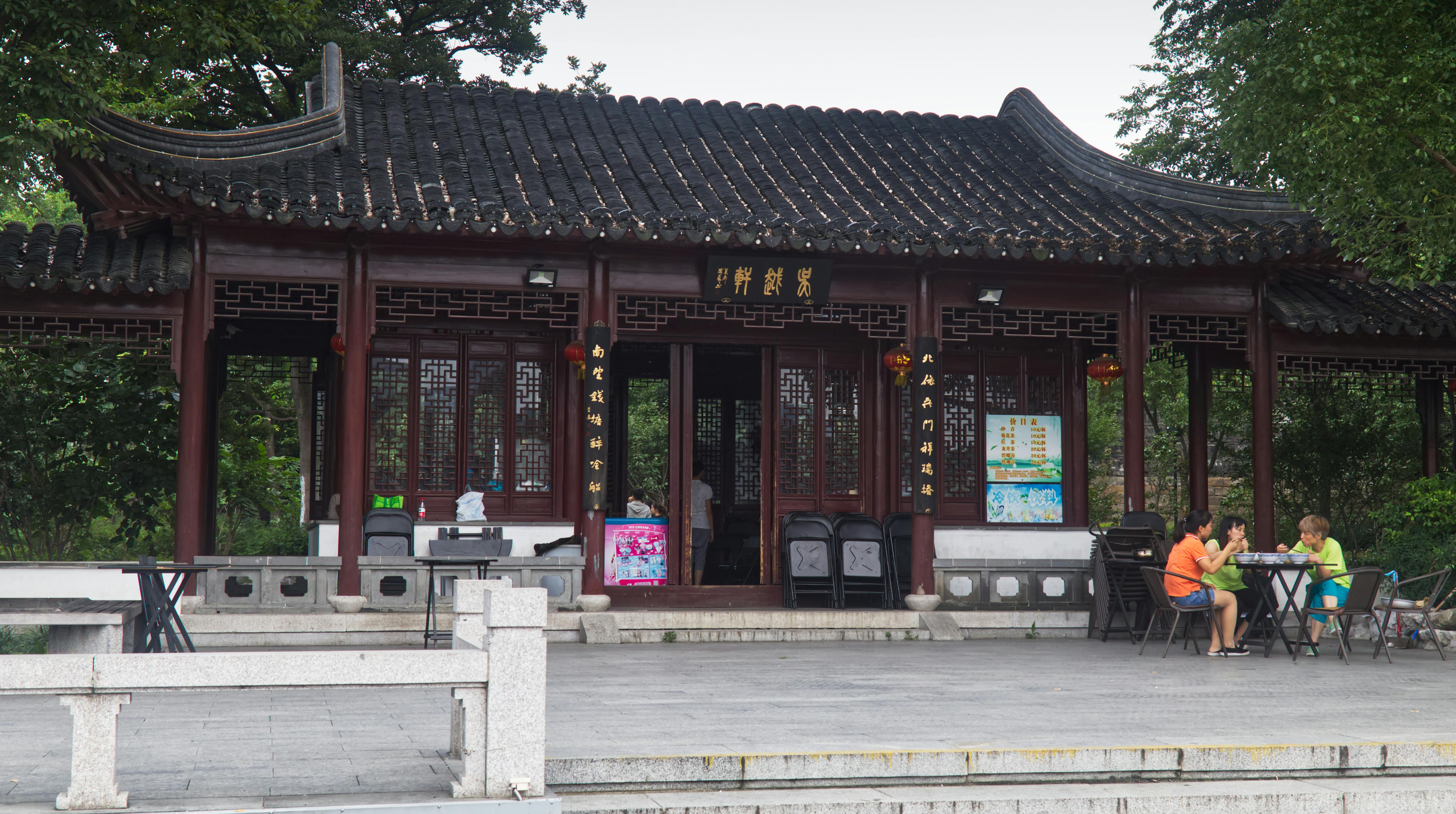 Chinese pavilion with people dining outside in Suzhou, Jiangsu, China.