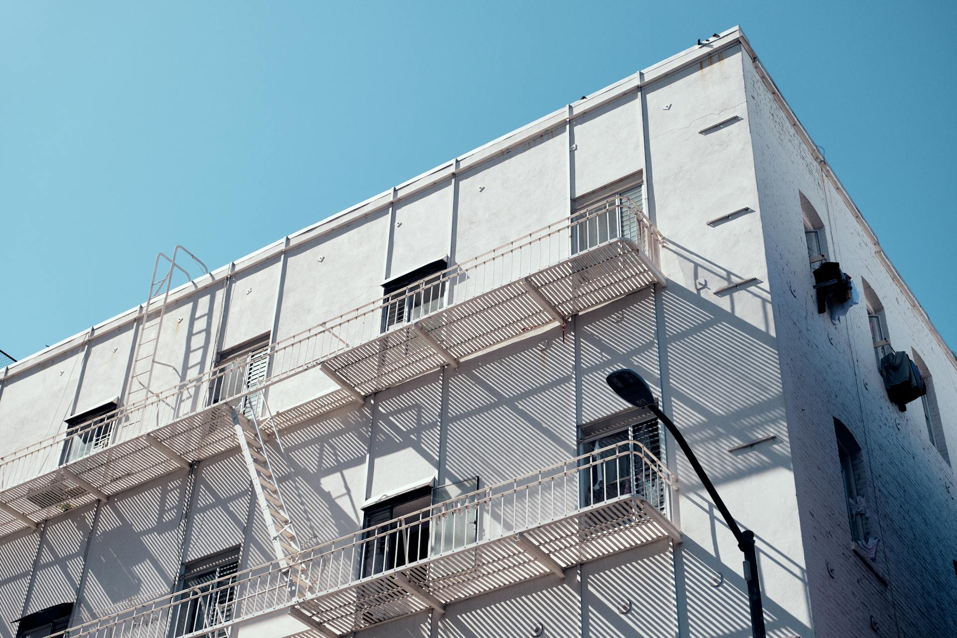 Modern building exterior with fire escapes, located in San Francisco under a clear blue sky.