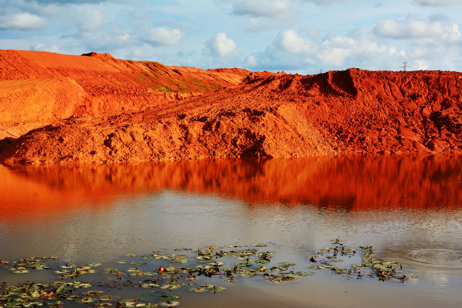 Scenic view of red earth reflected in a pond in Johor Bahru, Malaysia.