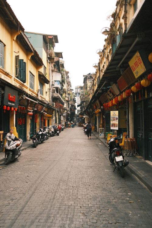 Free Picturesque street lined with traditional Asian shops and motorbikes in a historic town. Stock Photo