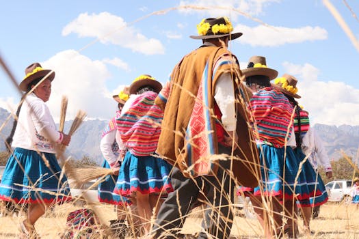Andean people in colorful attire participating in a traditional dance outdoors.