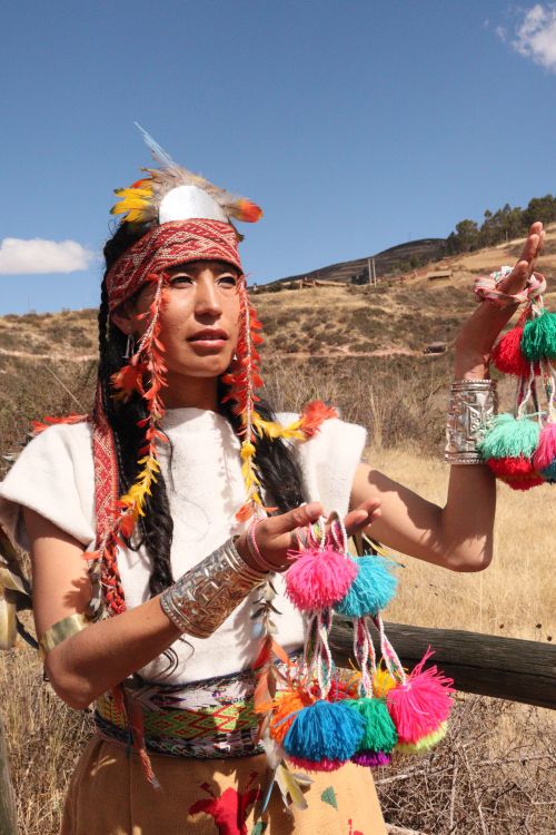 Free A woman in traditional clothing holding colorful tassels under a clear blue sky. Stock Photo