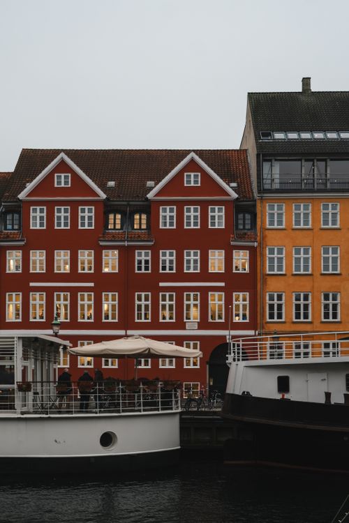 Free Scenic winter view of vibrant buildings and boats along Nyhavn in Copenhagen, Denmark. Stock Photo