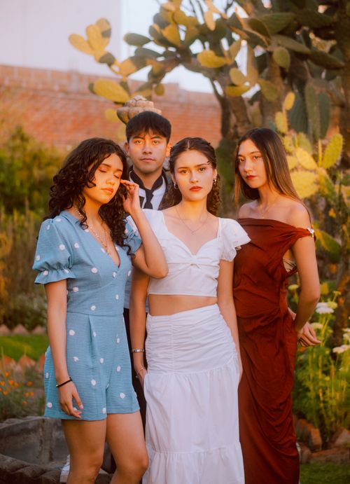 Free A group of young adults posing fashionably in an outdoor garden during golden hour. Stock Photo
