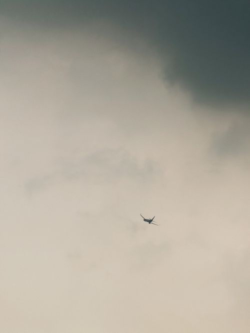 Free Airplane soaring through a cloudy and moody sky, symbolizing travel and adventure. Stock Photo