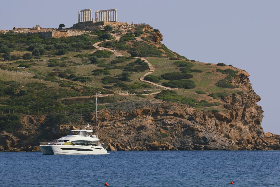 Outstanding Sailingboat: Kleftiko & Poliegos Full Day with Lunch & Open bar Review 2026 - Scenic view of Temple of Poseidon with yacht in Cape Sounion, Greece.