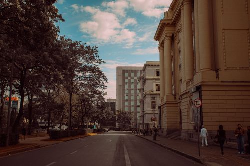 Free Street scene with historic architecture and modern buildings under a blue sky. Stock Photo