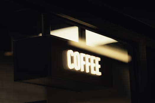 A sleek, minimalistic coffee shop sign illuminated in soft ambient light, perfect for urban lifestyle themes.
