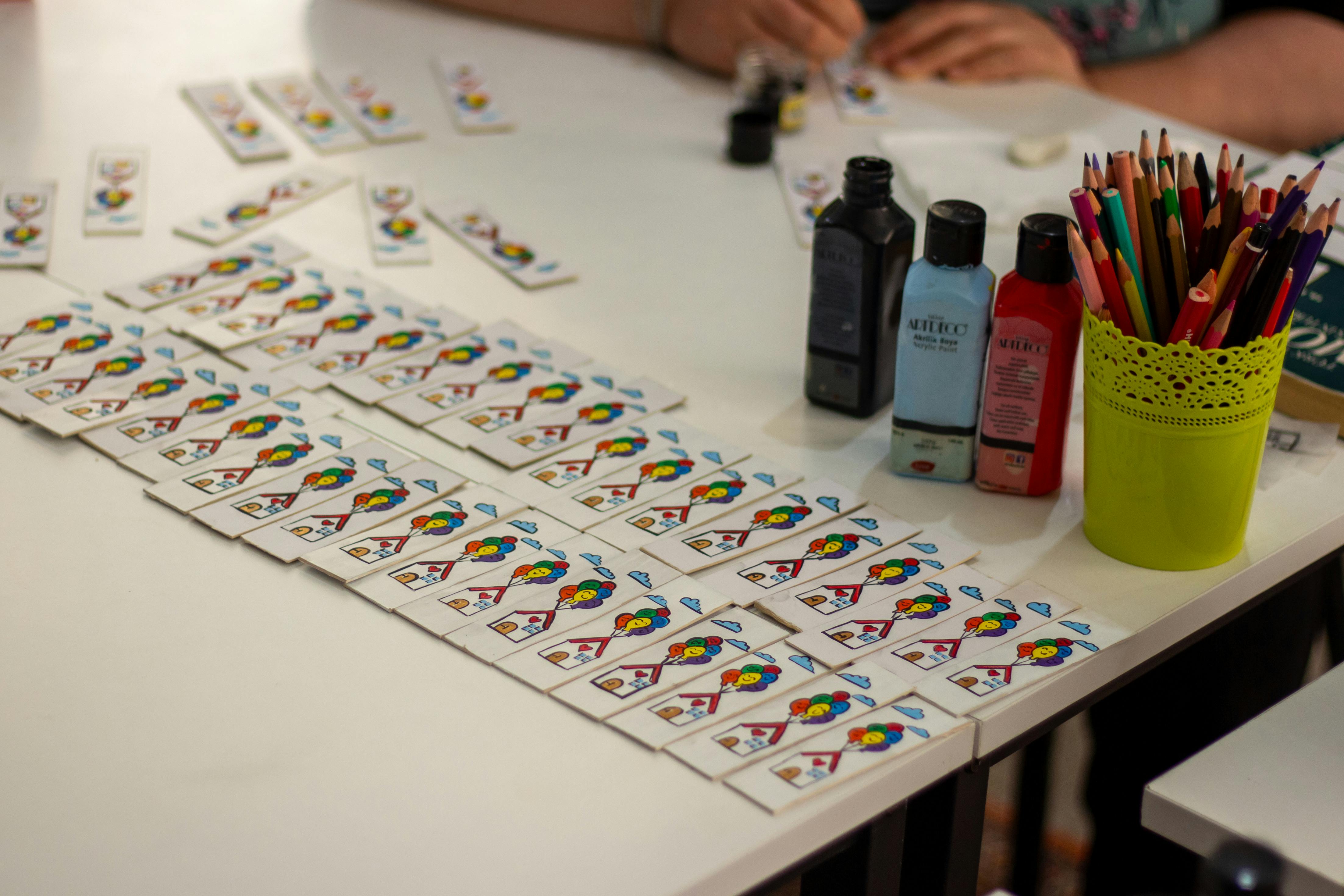 Vibrant DIY card crafting setup with paint and pencils on display.