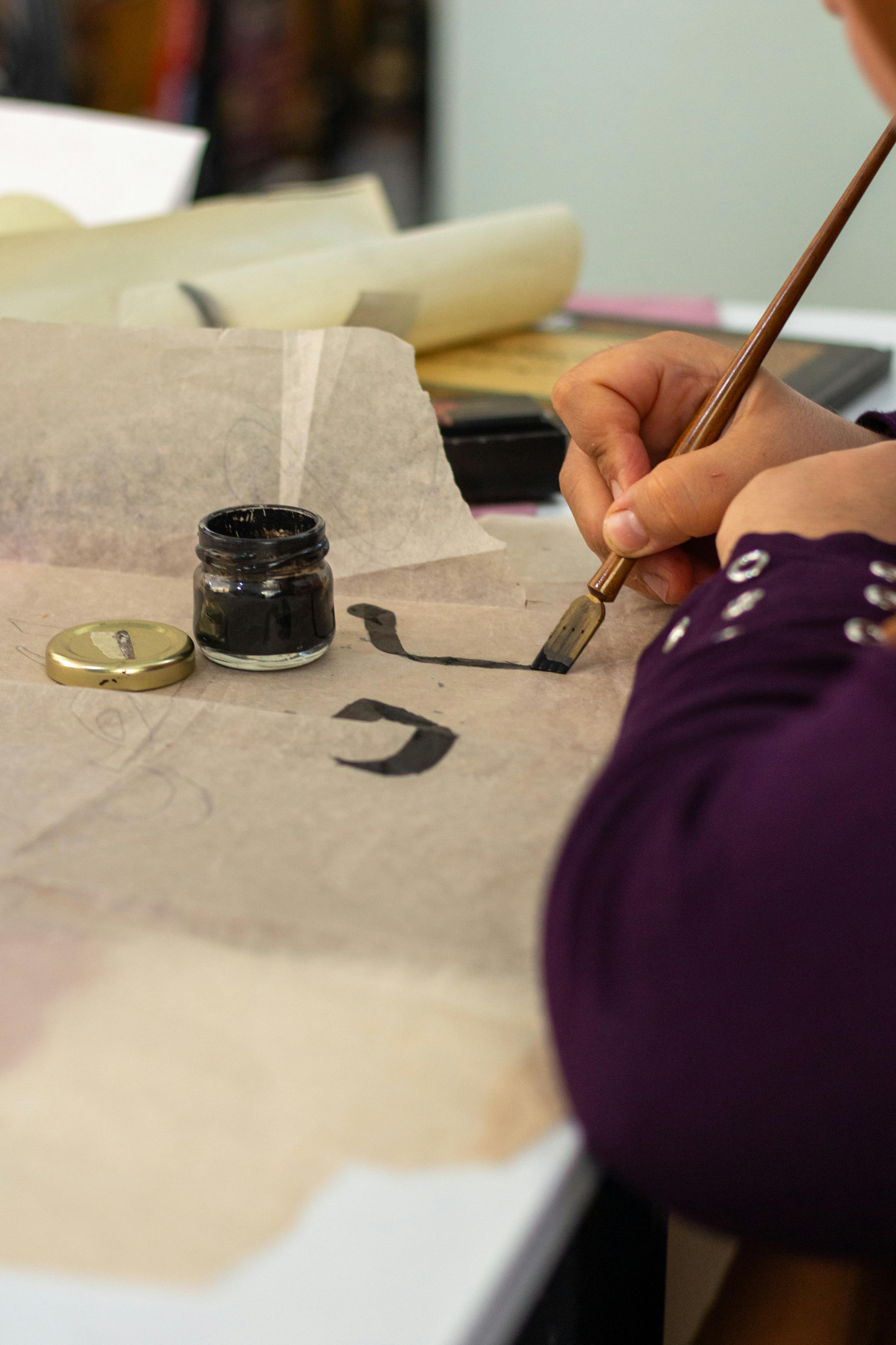 Artistic Calligraphy Writing with Ink and Brush · Free Stock Photo