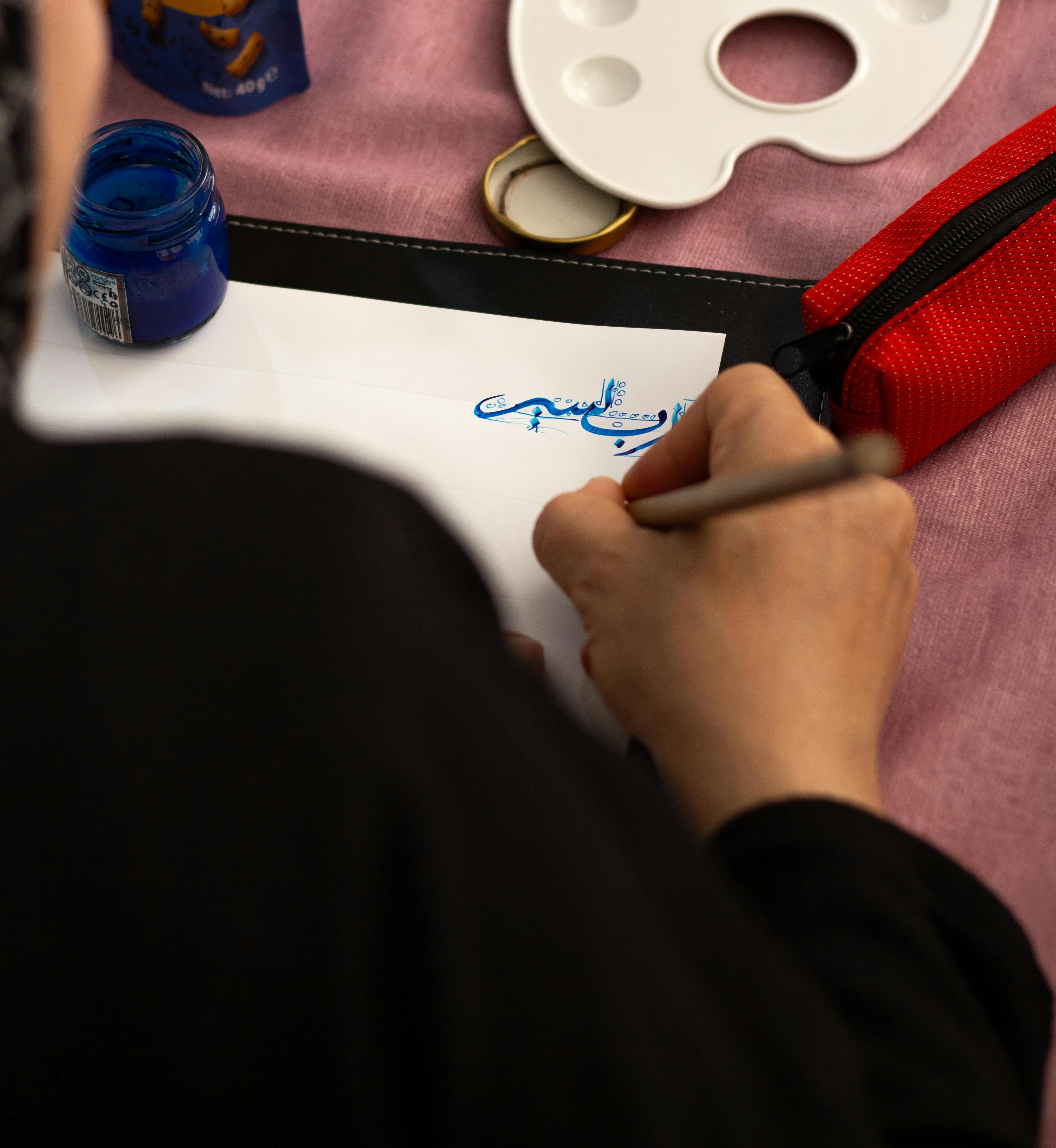 gratis Close-up van een persoon die binnenshuis blauwe inktkalligrafie beoefent. Stockfoto