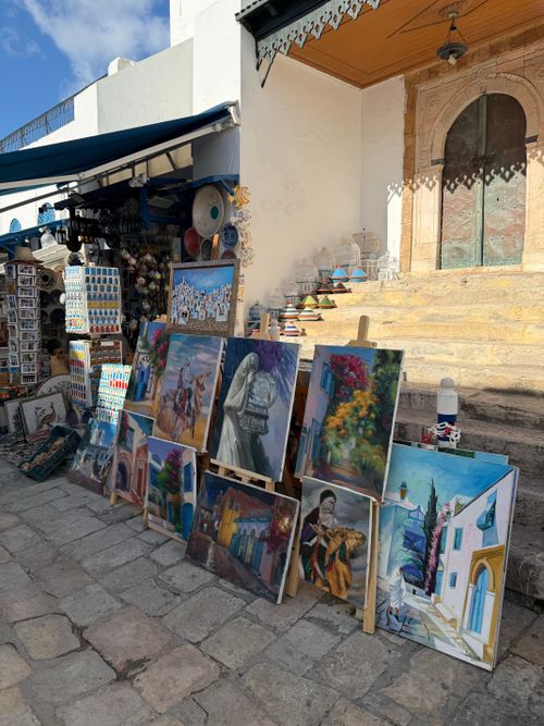 Free Vibrant local paintings displayed in an outdoor Mediterranean market. Stock Photo