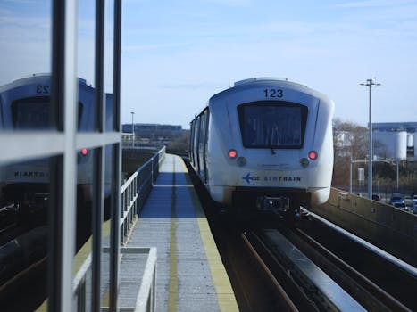 AirTrain approaches JFK airport station in New York on a clear day.
