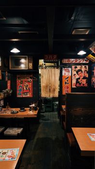 Warm interior of a traditional Japanese izakaya with vintage decor and wooden seating.