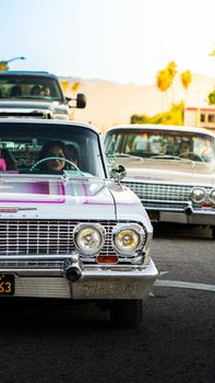 Vintage cars parading on a sunny street in San Bernardino, CA.