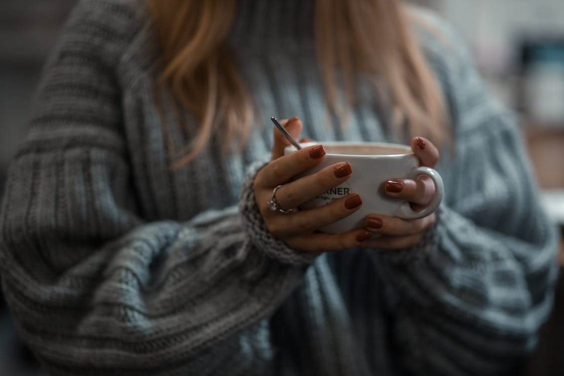 Woman in Gray Sweater Holding White Ceramic Mug