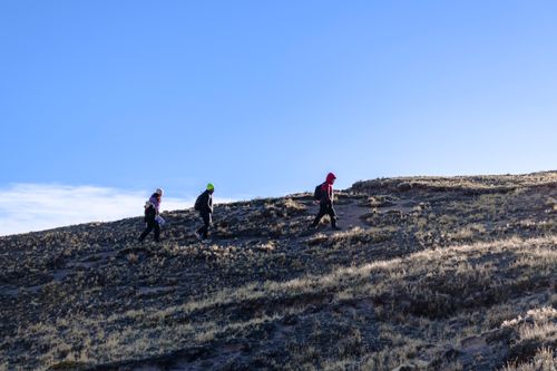 Free Three hikers traverse the rugged terrain in Arequipa, Peru under clear blue skies. Stock Photo