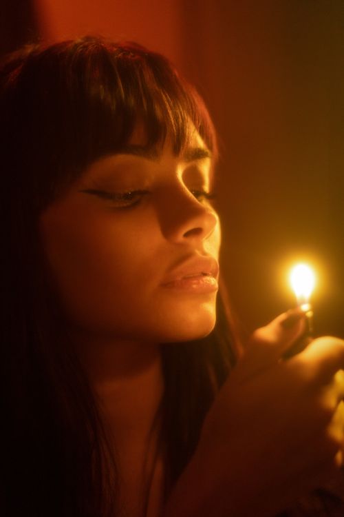 Free Portrait of a woman in soft candlelight creating a warm, serene atmosphere. Stock Photo