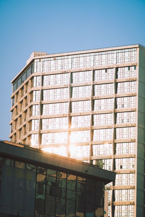 Free Glass facade skyscraper reflecting sunlight under a clear blue sky, urban architecture. Stock Photo