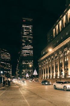 Vibrant city street at night with illuminated buildings and bustling traffic.