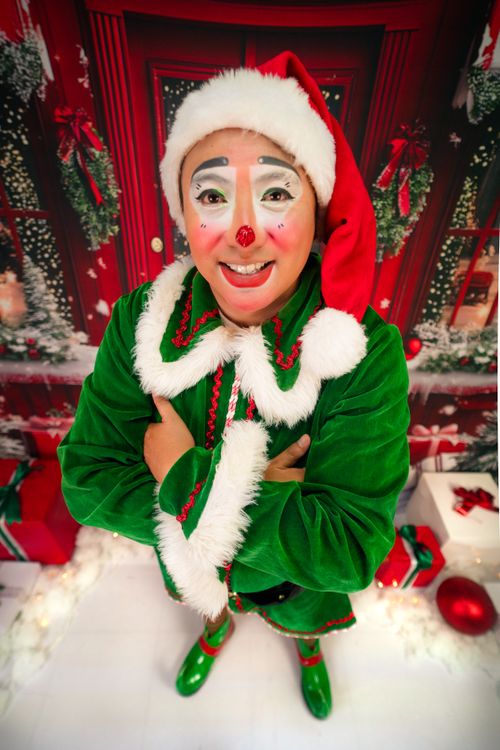 Free Brightly dressed clown in Christmas costume smiling in a festive holiday setting. Stock Photo
