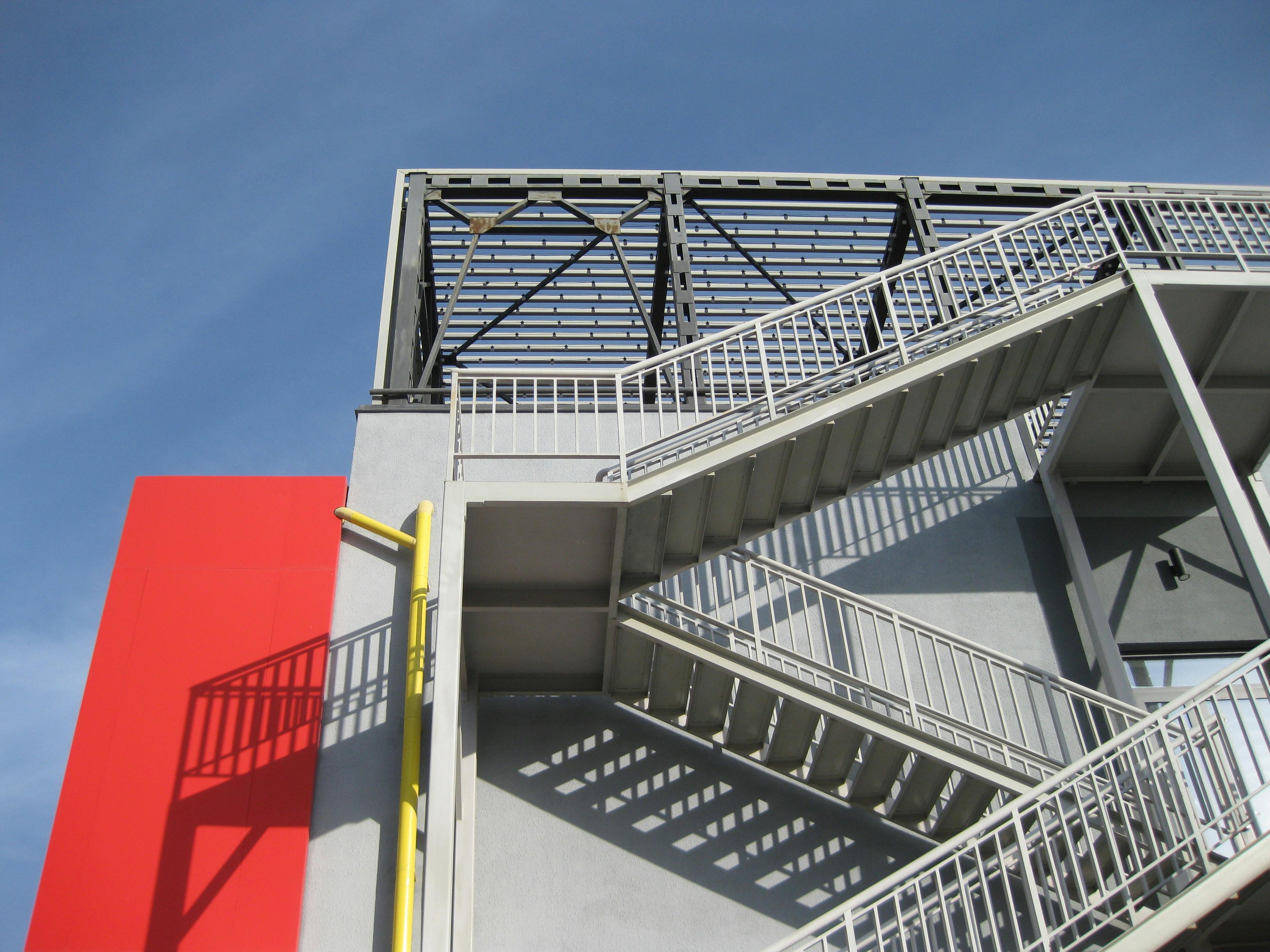 Modern exterior staircase with metal railings attached to a contemporary building structure