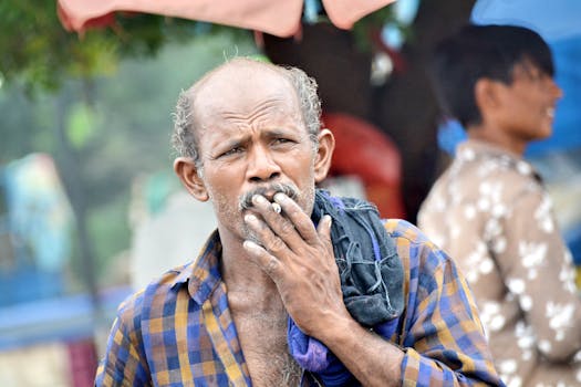 Ritratto di un uomo anziano che fuma all'aperto. Immerso nei suoi pensieri e introspettivo, in un ambiente informale.