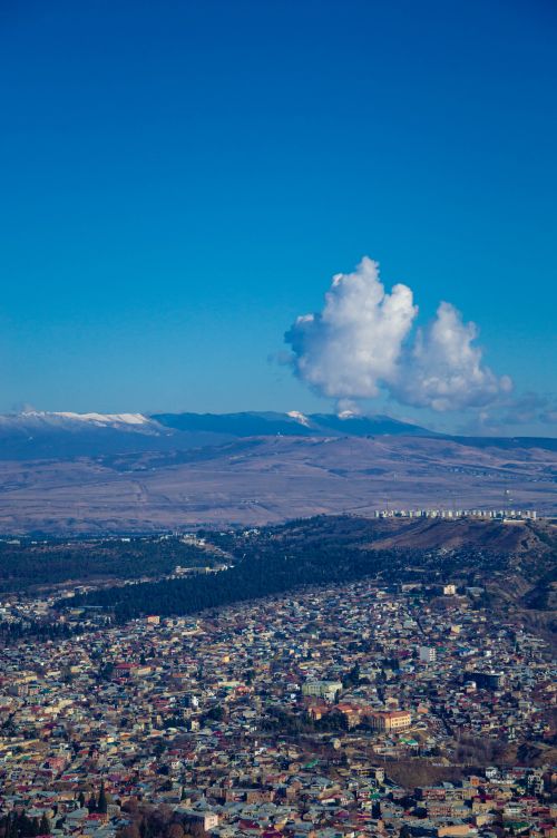 Free A stunning aerial view of Tbilisi with mountains and clouds in the backdrop. Stock Photo