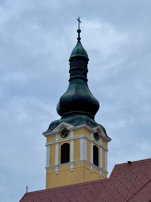Free Elegant church tower with intricate architecture stands tall under a cloudy sky in Našice, Croatia. Stock Photo