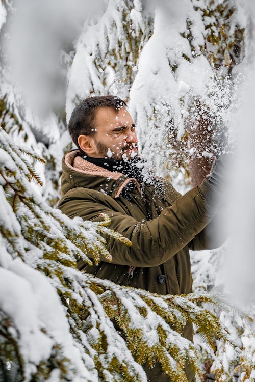 Man Standing Beside Tree With Snow