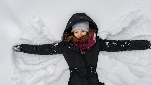 免费 黑色外套和灰色针织帽在雪地上的女人 素材图片