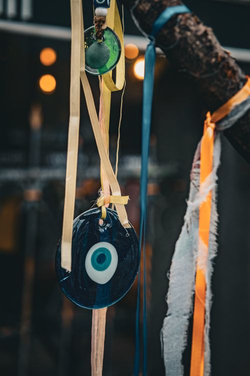 Free A vibrant evil eye talisman hanging with colorful ribbons outdoors on a tree branch. Stock Photo