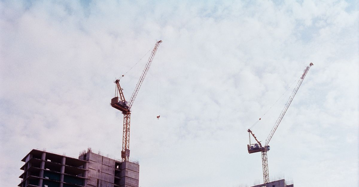 Construction site showcasing high-rise buildings with tower cranes under a bright blue sky in Vũng Tàu, Vietnam.