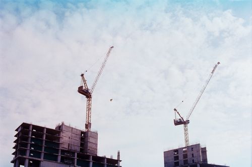 Free Construction site showcasing high-rise buildings with tower cranes under a bright blue sky in Vũng Tàu, Vietnam. Stock Photo