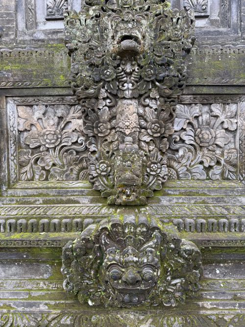 Free Detailed Balinese stone carving adorned with moss and floral patterns. Stock Photo