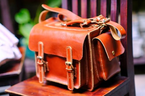 Free A detailed shot of a handcrafted leather bag on a wooden chair in Hue, Vietnam. Stock Photo