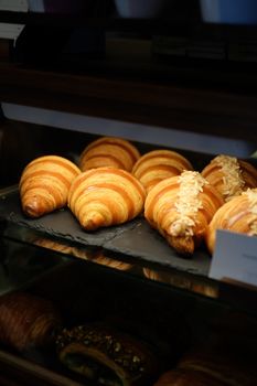 Golden croissants in a bakery showcase inviting breakfast delights.