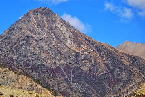 Free Breathtaking view of a rugged mountain peak against a vibrant blue sky, showcasing natural beauty and geological formations. Stock Photo