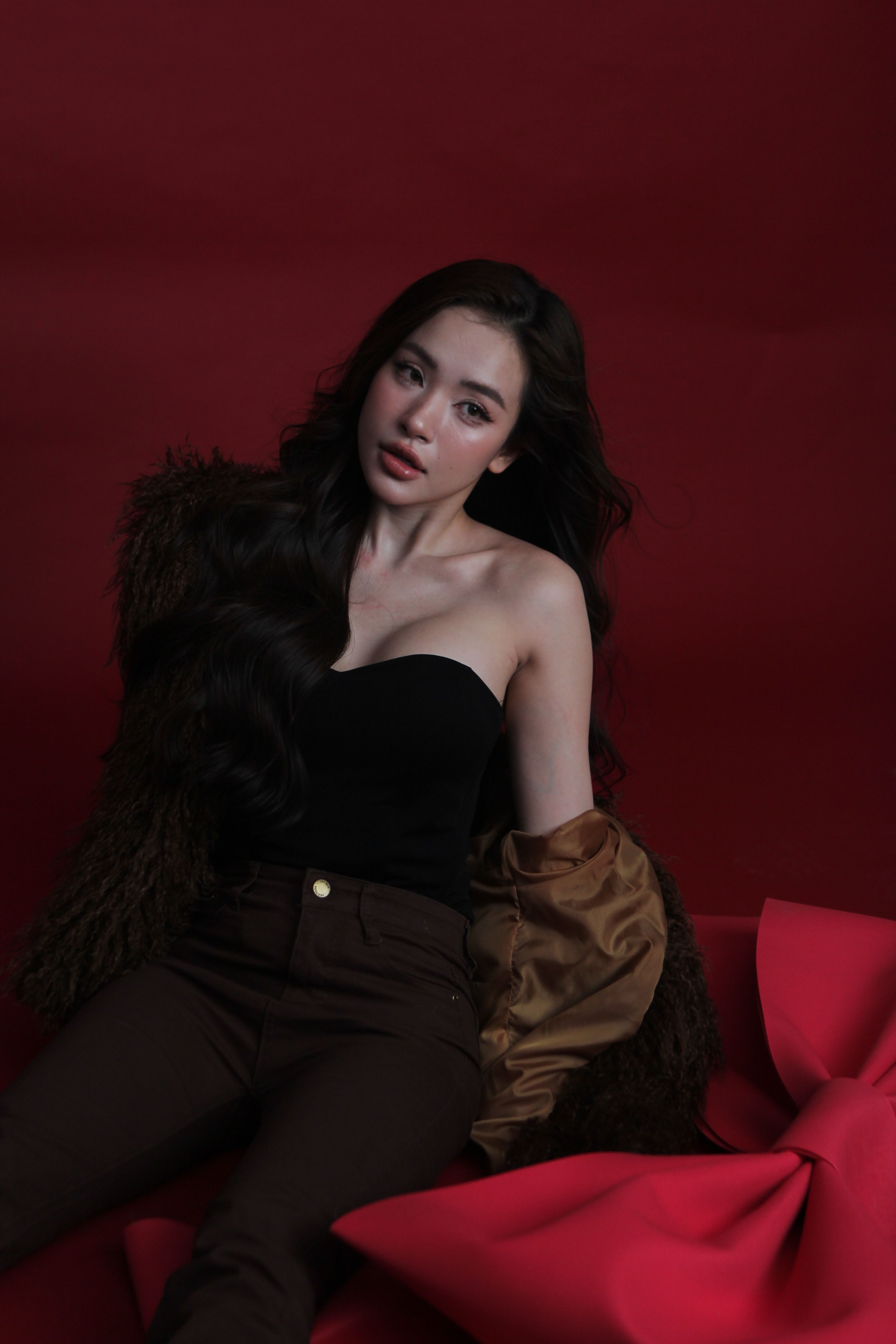 Elegant Portrait of Woman Against Red Backdrop · Free Stock Photo