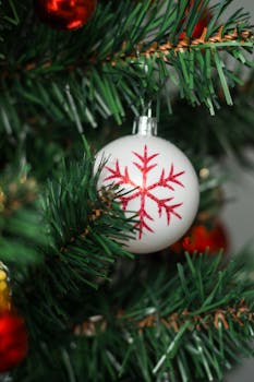 Close-up of a snowflake ornament on a decorated Christmas tree, evoking holiday spirit.